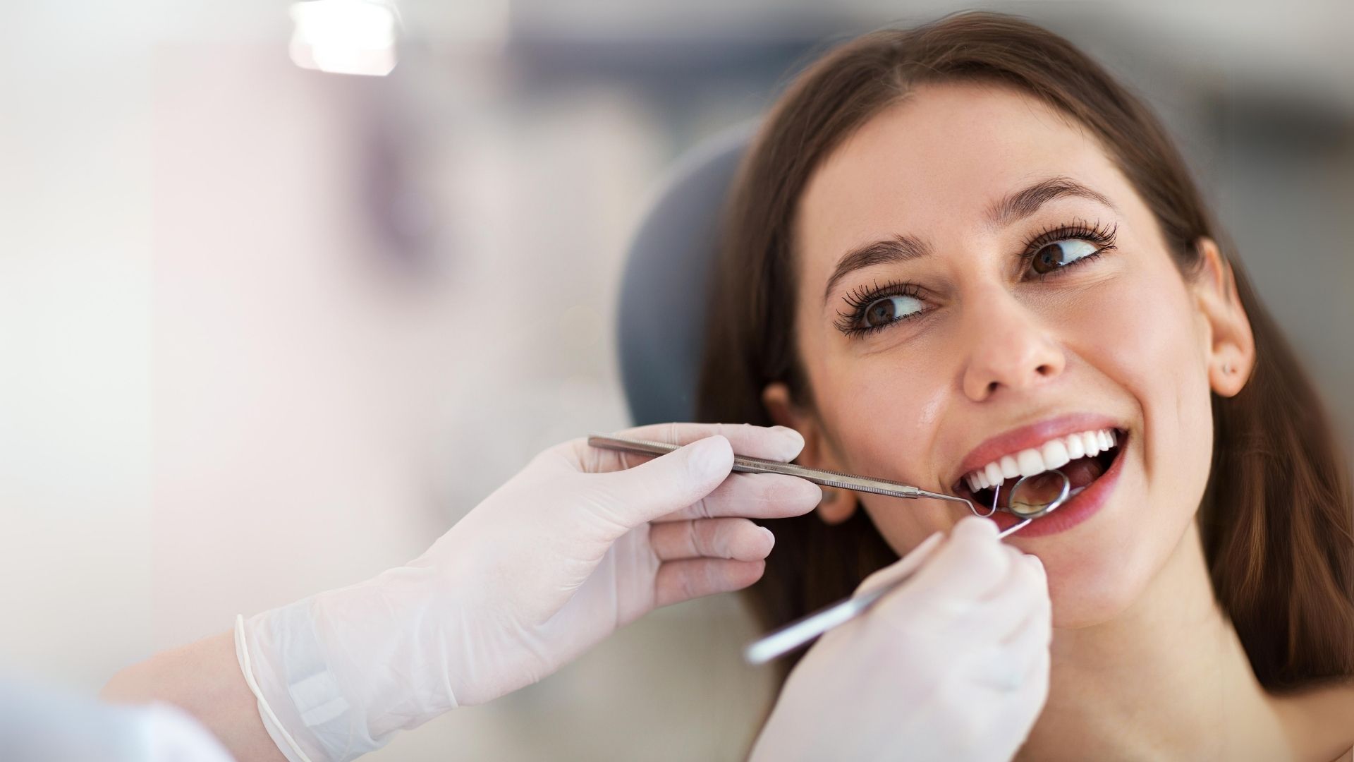 Mulher adulta a receber uma avaliação dentária numa clínica