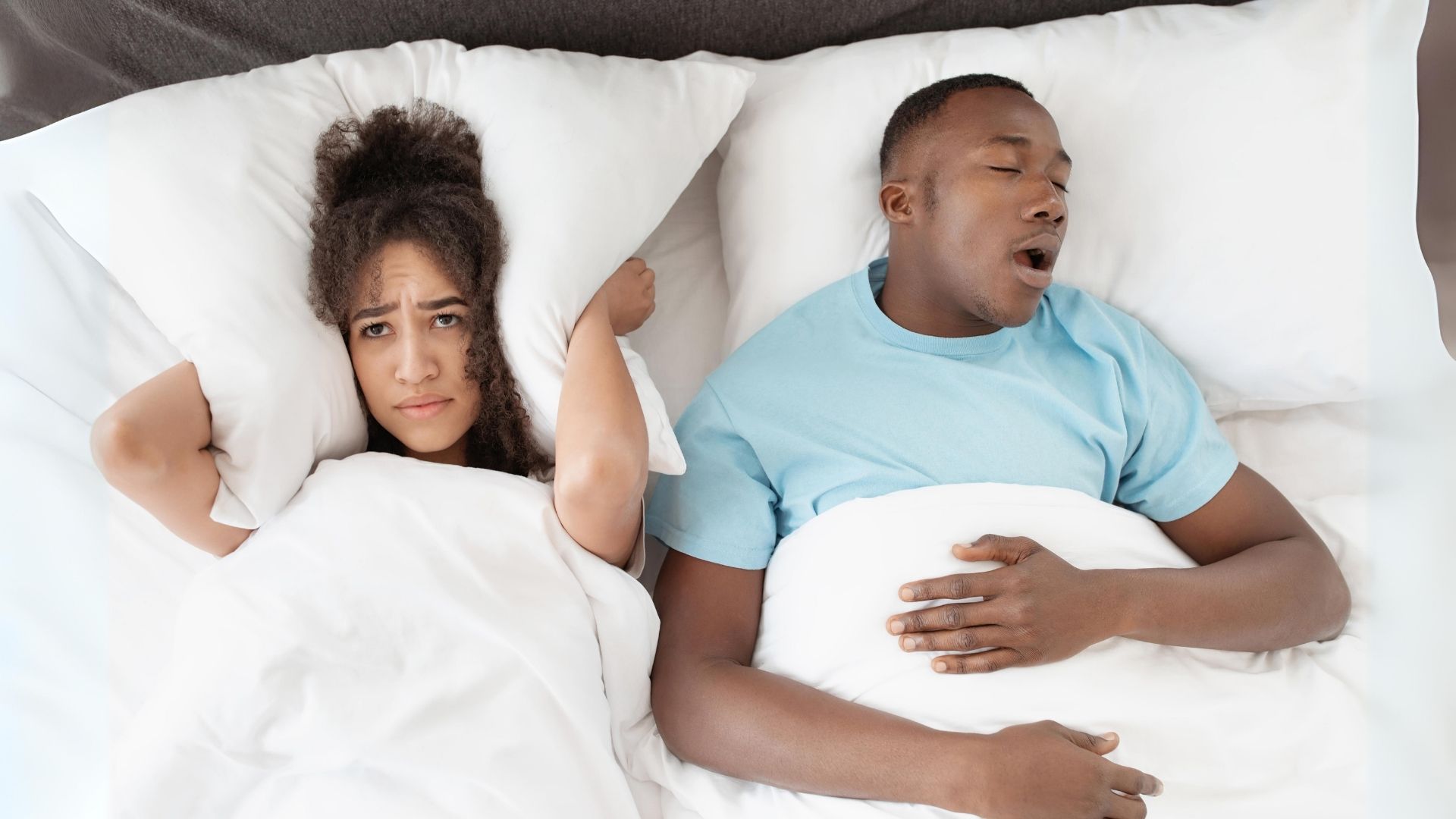 Casal deitado a dormir enquanto um dos parceiros parece ressonar