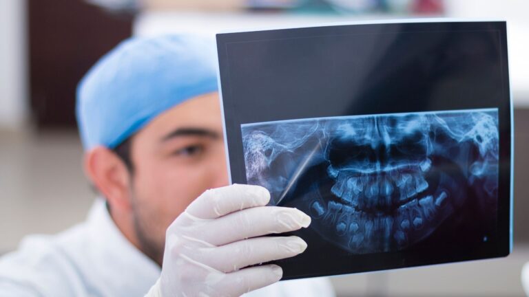 Profissional a analisar uma radiografia panorâmica dentária