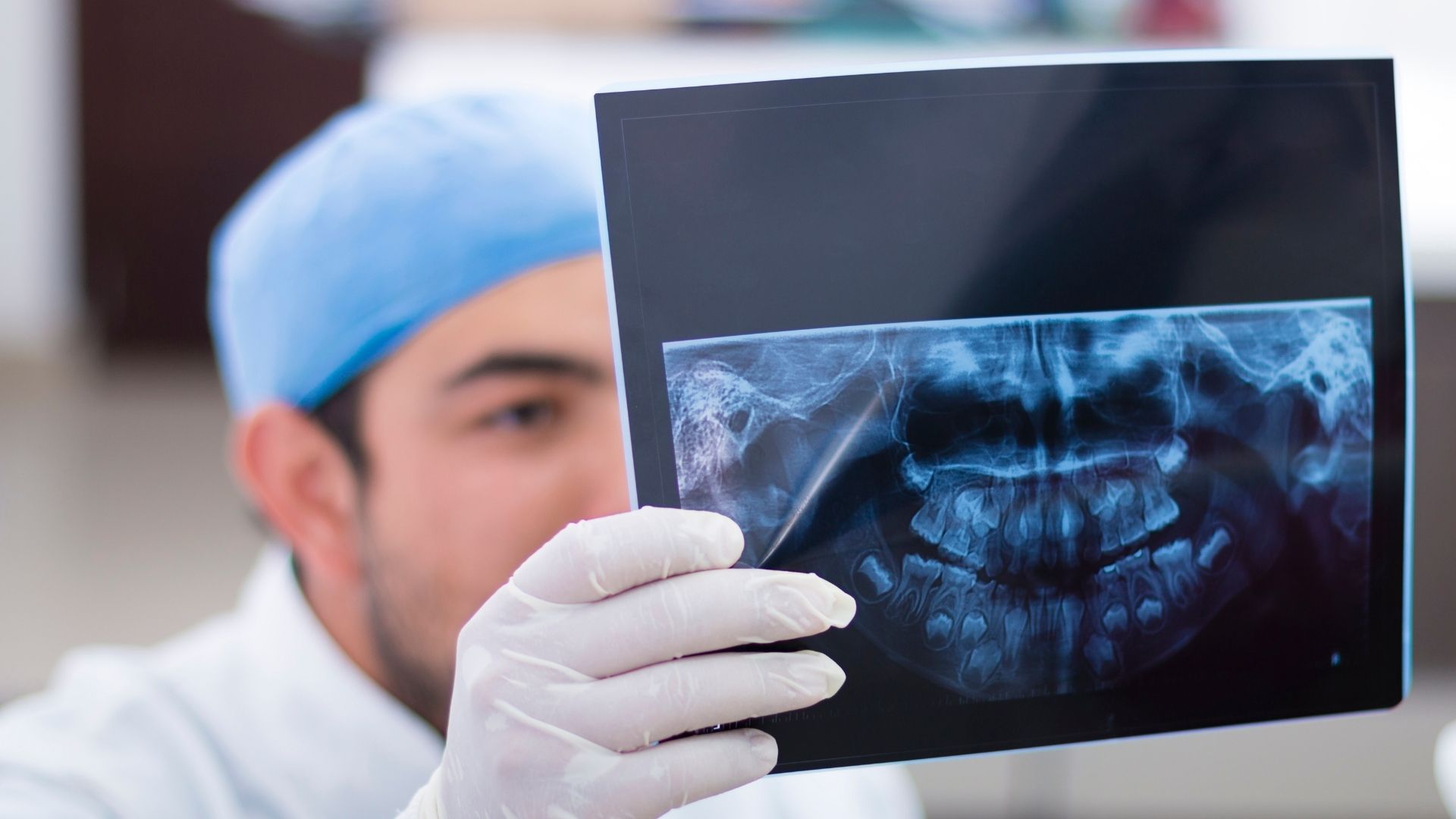 Profissional a analisar uma radiografia panorâmica dentária